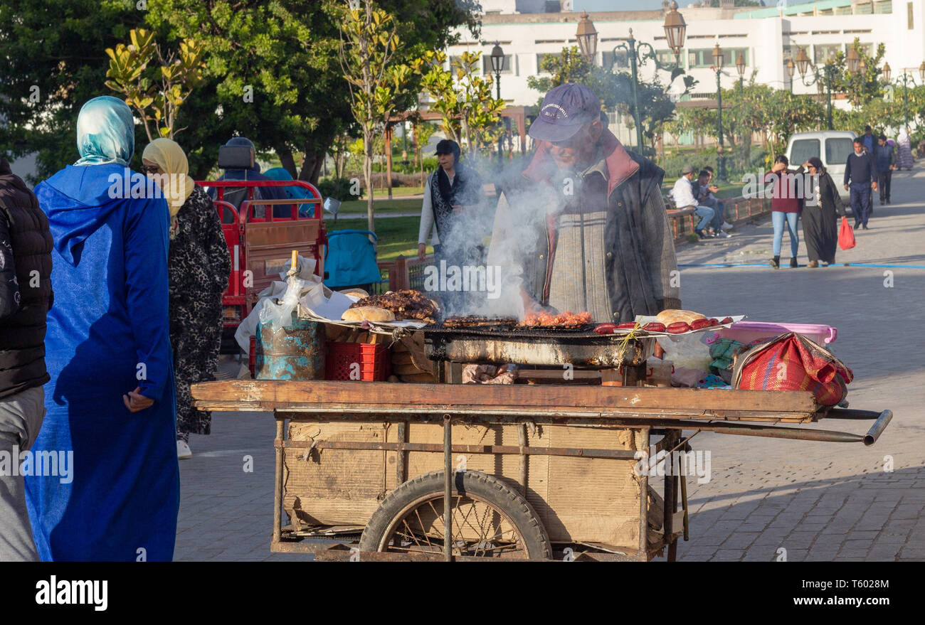 Medina Of Rabat, Morocco, April 27 2019. A local man cooking traditional Moroccan food outdoors in a market square on a barbecue. Stock Photo