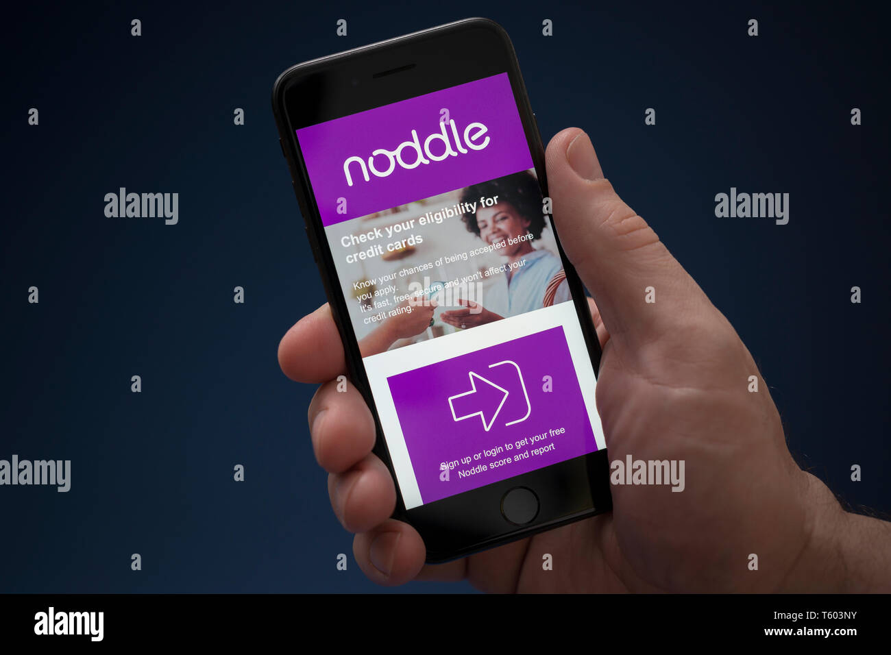 A man looks at his iPhone which displays the Noddle logo (Editorial use only). Stock Photo
