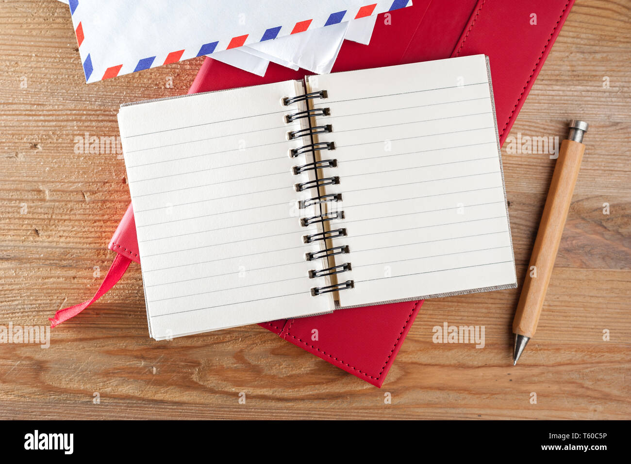 wooden desktop with blank notebook paper background, writing concept