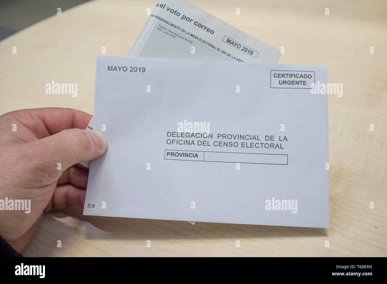 Mature man holds request form and envelope for absentee vote or postal vote. 2019 Spanish general election Stock Photo