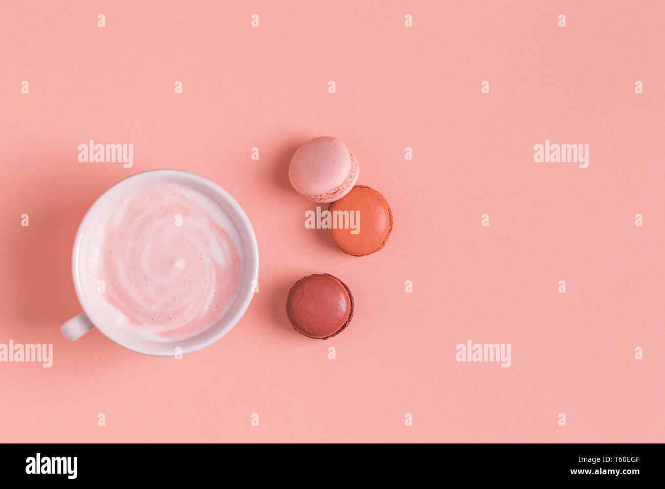 Cup of coffee with macaroons on pastel background, flat lay. Stock Photo