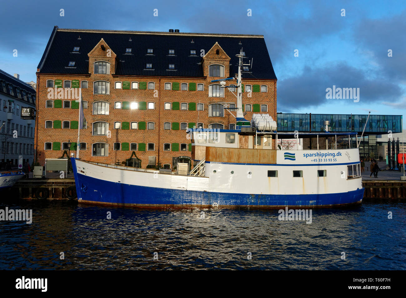 Old boat moored in front of a building on the Nyhavn canal, Copenhagen, Denmark, Europe Stock Photo