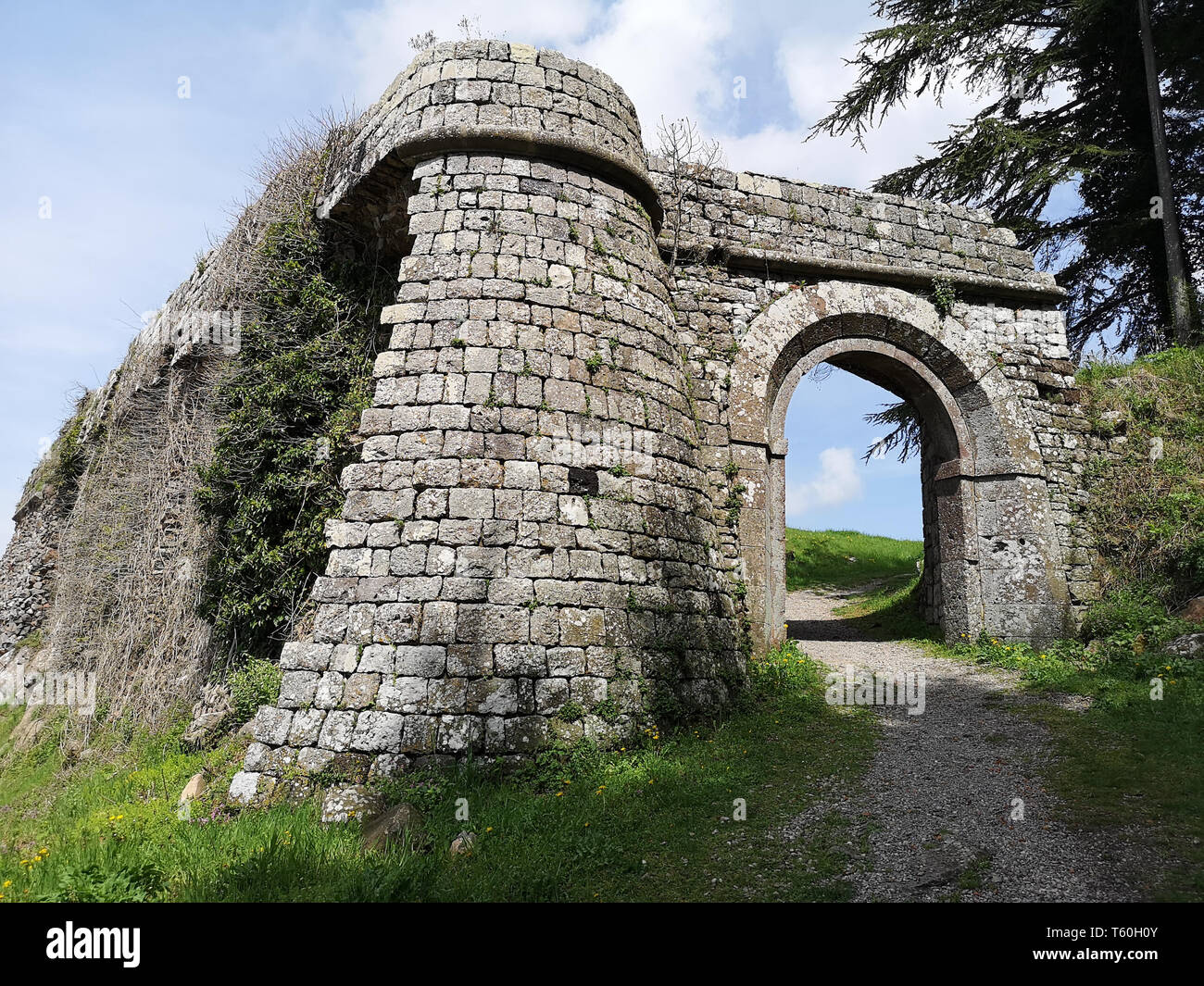 Detail of the stone entrance along the wall surrounding a medieval village. Stock Photo