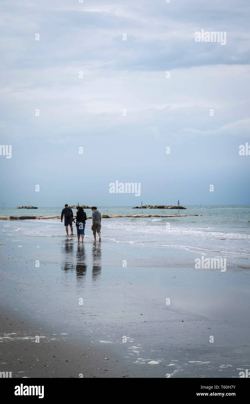 Beach After Rian People walking at a September beach after the rain Stock Photo - Alamy