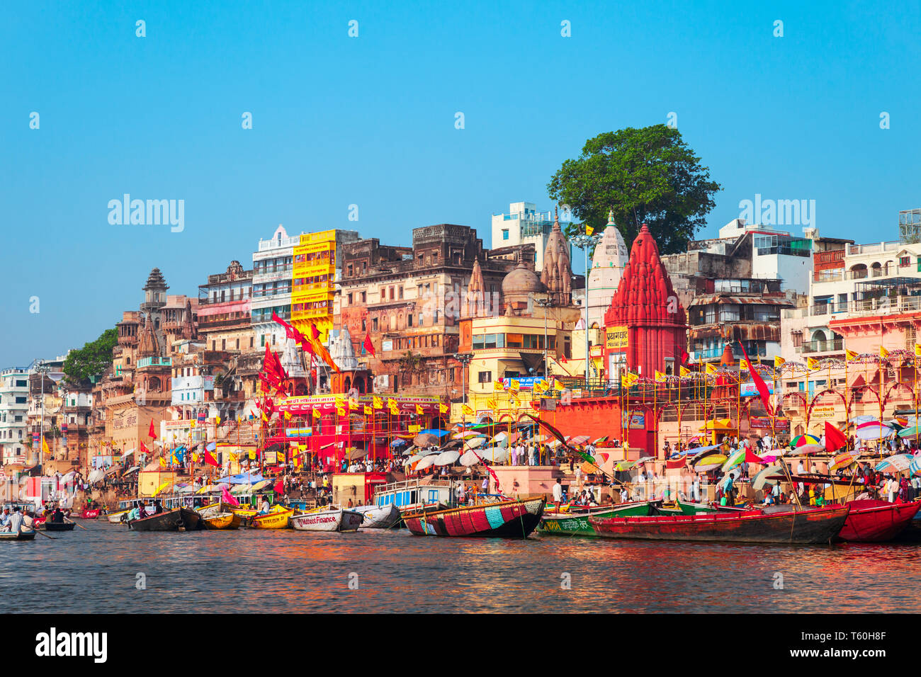 VARANASI, INDIA - APRIL 12, 2012: Colorful boats and Ganges river bank in Varanasi city in India Stock Photo