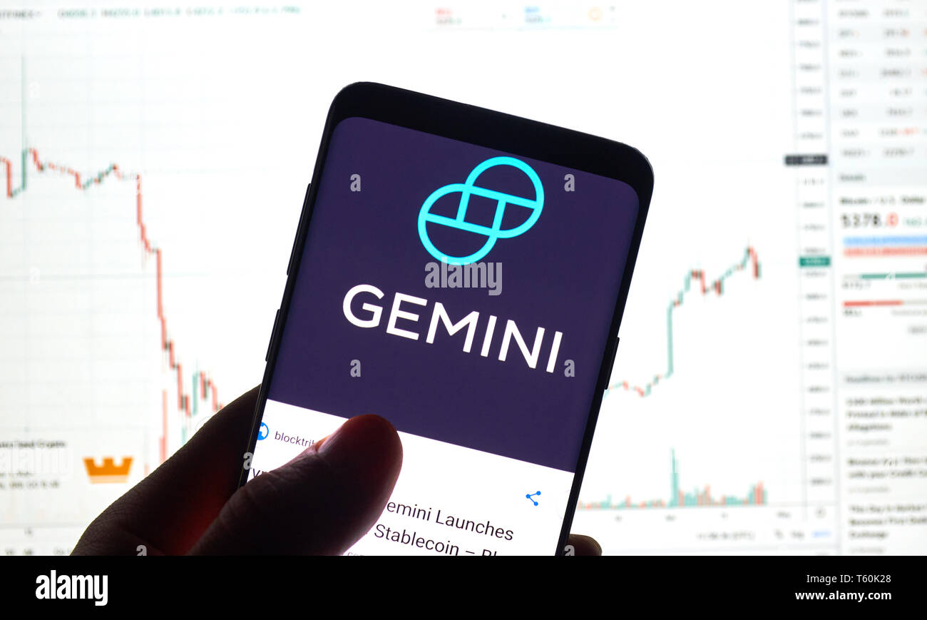 MONTREAL, CANADA - APRIL 26, 2019: Gemini cryptocurrency exchange logo and application on Android Samsung Galaxy s9 Plus screen in a hand over a lapto Stock Photo