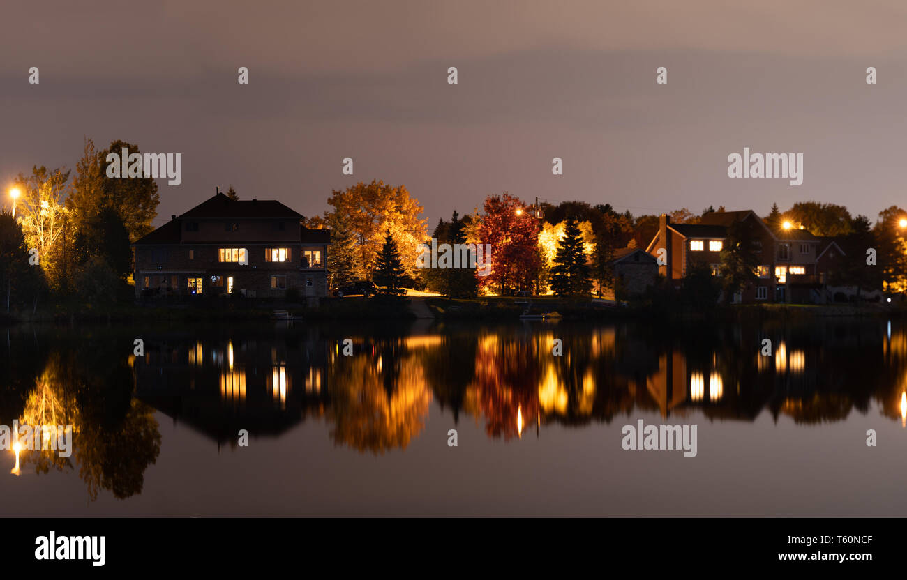 Reflections on the Water on Richard Lake in Ontario, Canada during blue hour with the lights from the cottages. Stock Photo