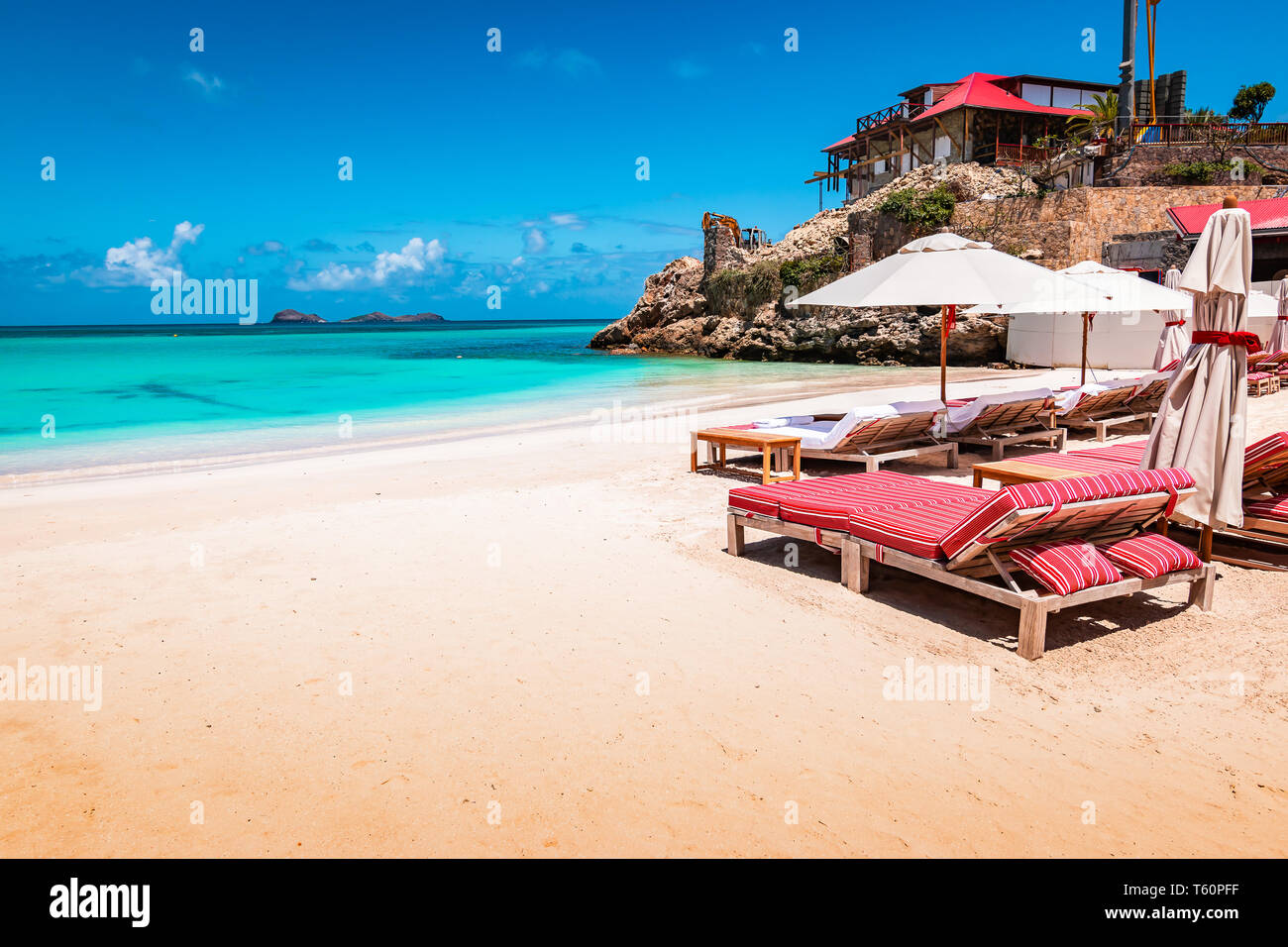 Luxury beach chairs and umbrella on exotic beach in St Barths, Caribbean Island. Stock Photo