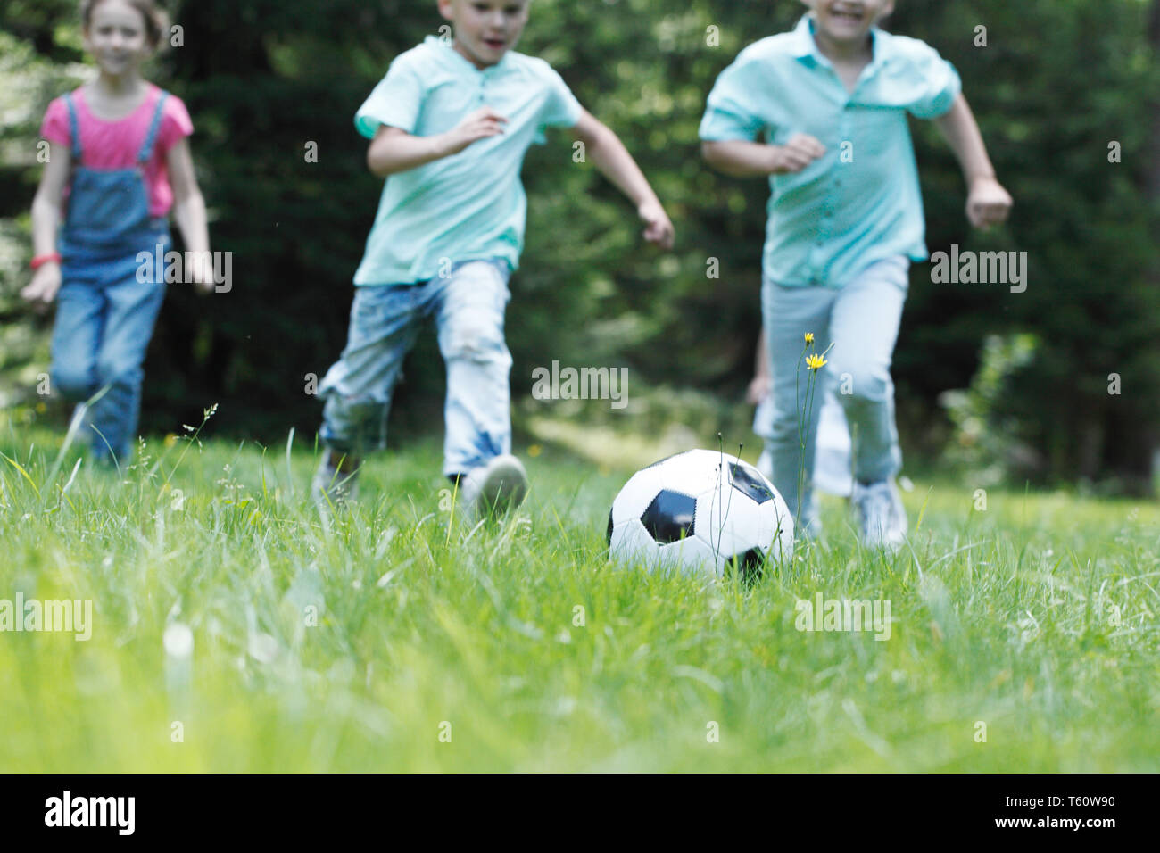 Happy children playing football in summer park Stock Photo - Alamy