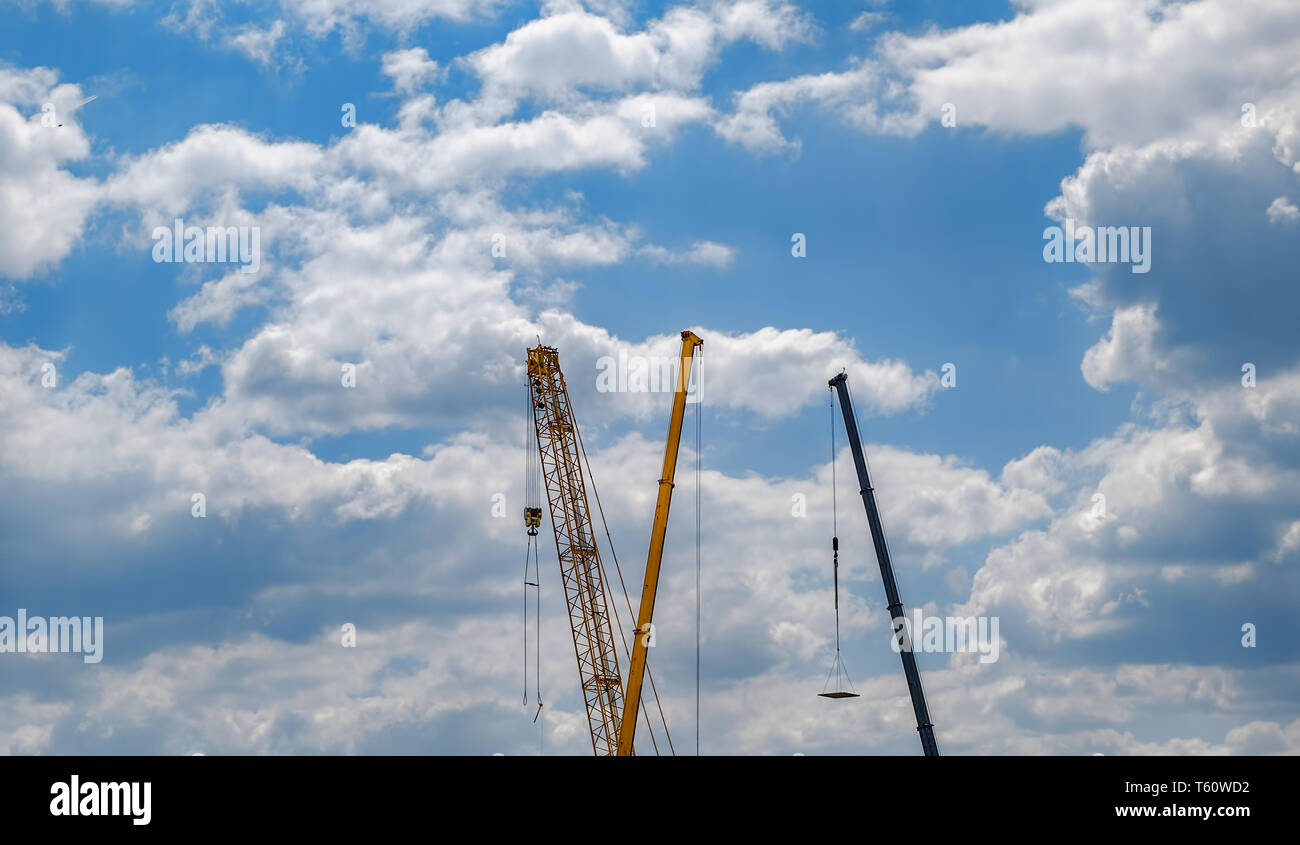 construction cranes in the blue sky with clouds Stock Photo - Alamy