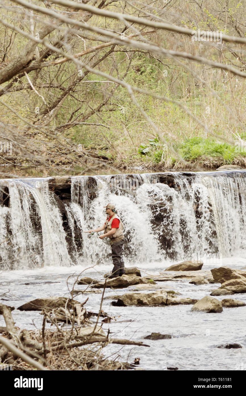 Man fishing in Ridley Creek, in Ridly Creek State Park in eastern Pennsylvania. Mid day in the