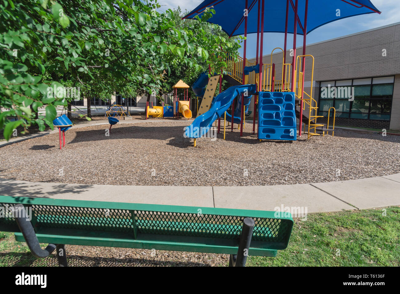Bench and playground with colorful structure equipment near Dallas