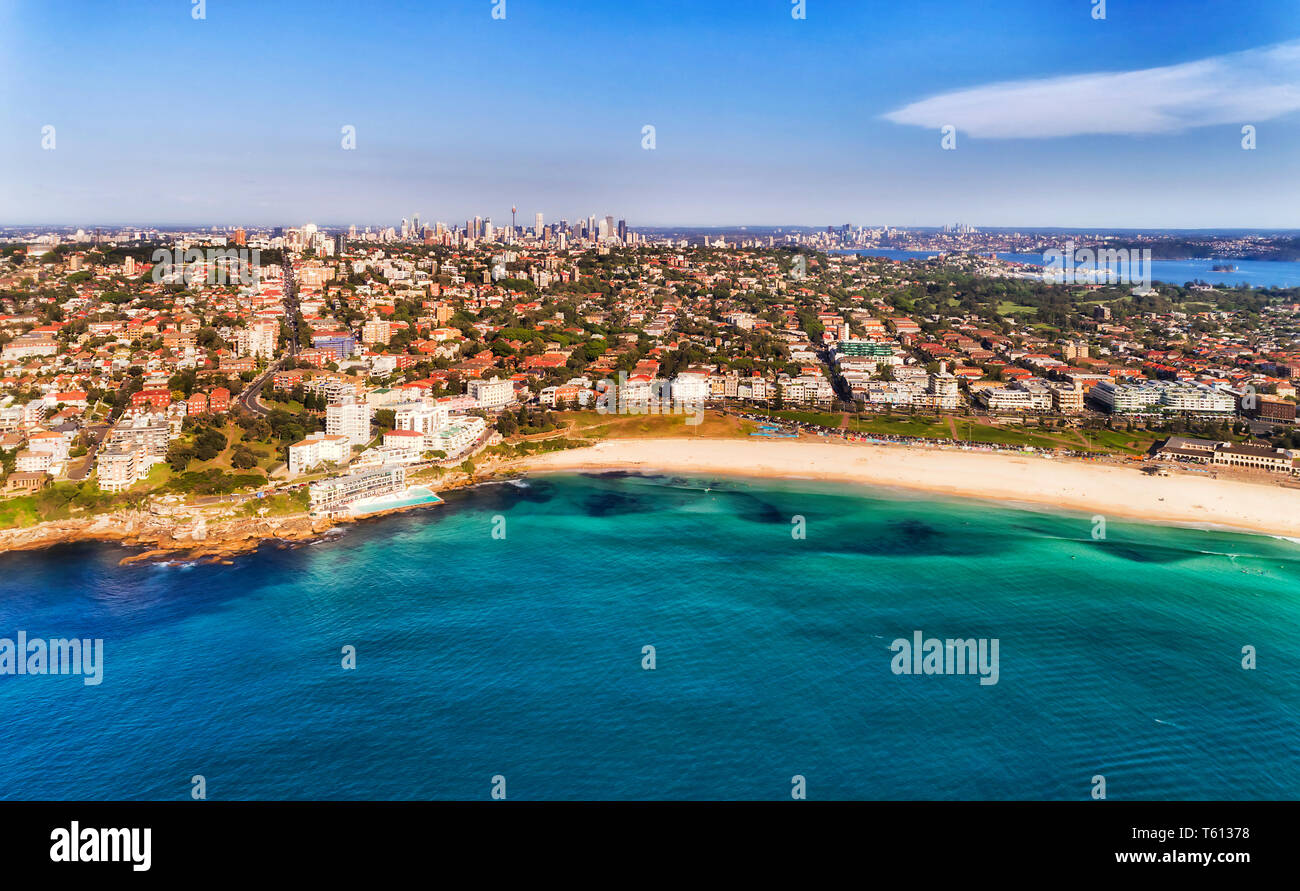 Waterfront of famous Bondi beach in Sydney from emerald waters of Pacific ocean to distant city CBD cityscape on the horizon on a sunny day. Stock Photo