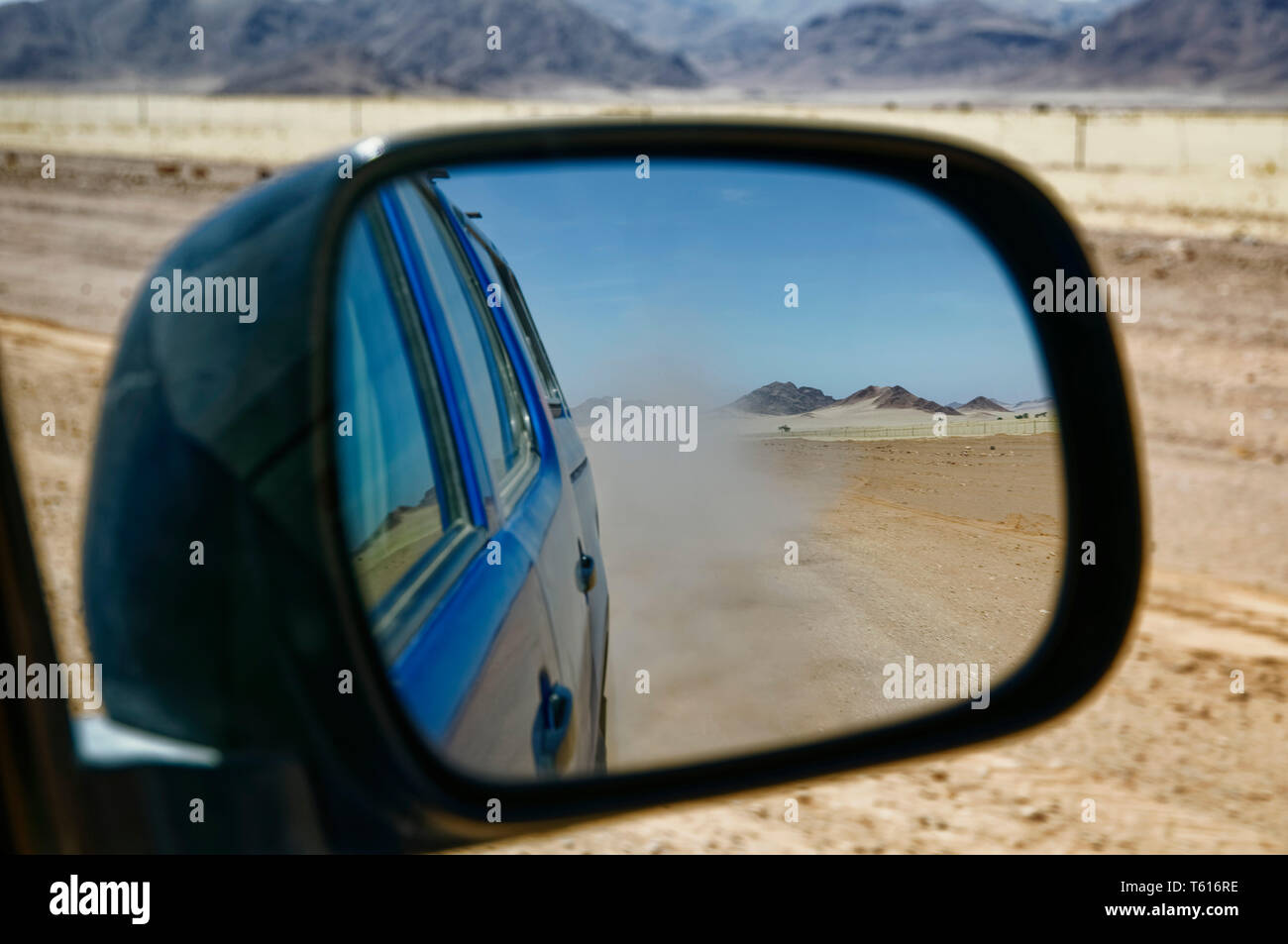 View in driving mirror: car on road C27 south of Sesriem, Namib Desert,   District, Hardap Region, Maltahöhe, Namibia Stock Photo