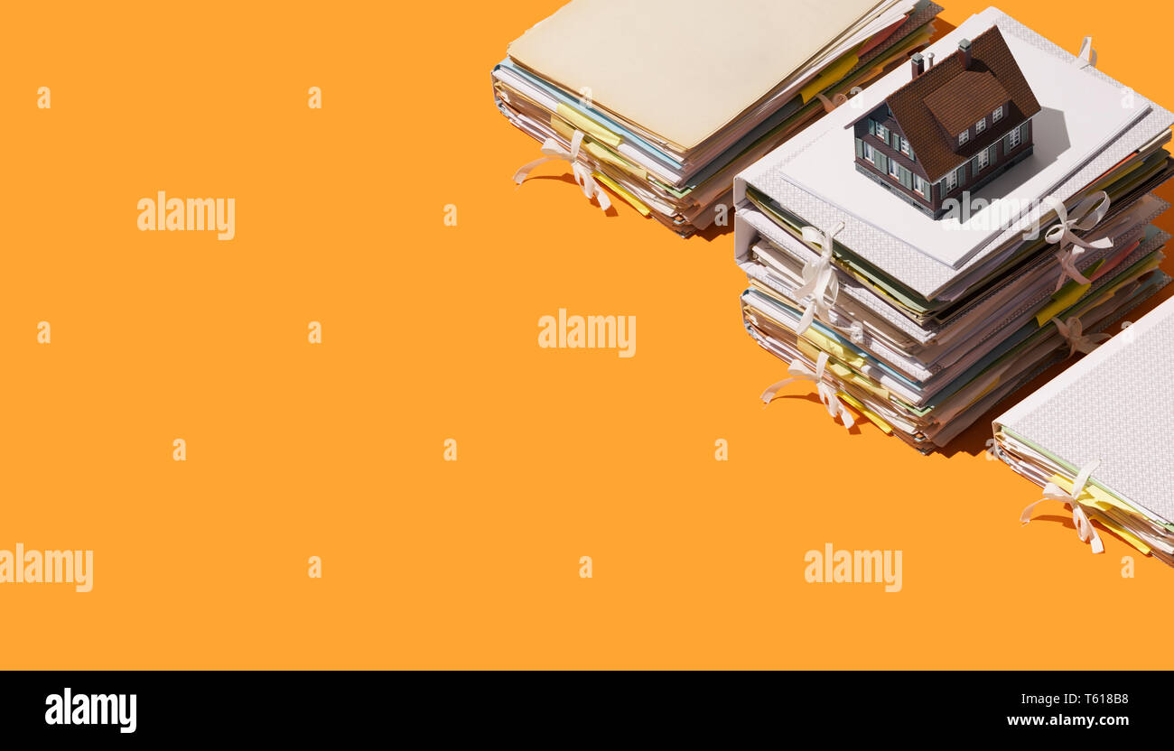Real estate and paperwork model house and piles of documents and