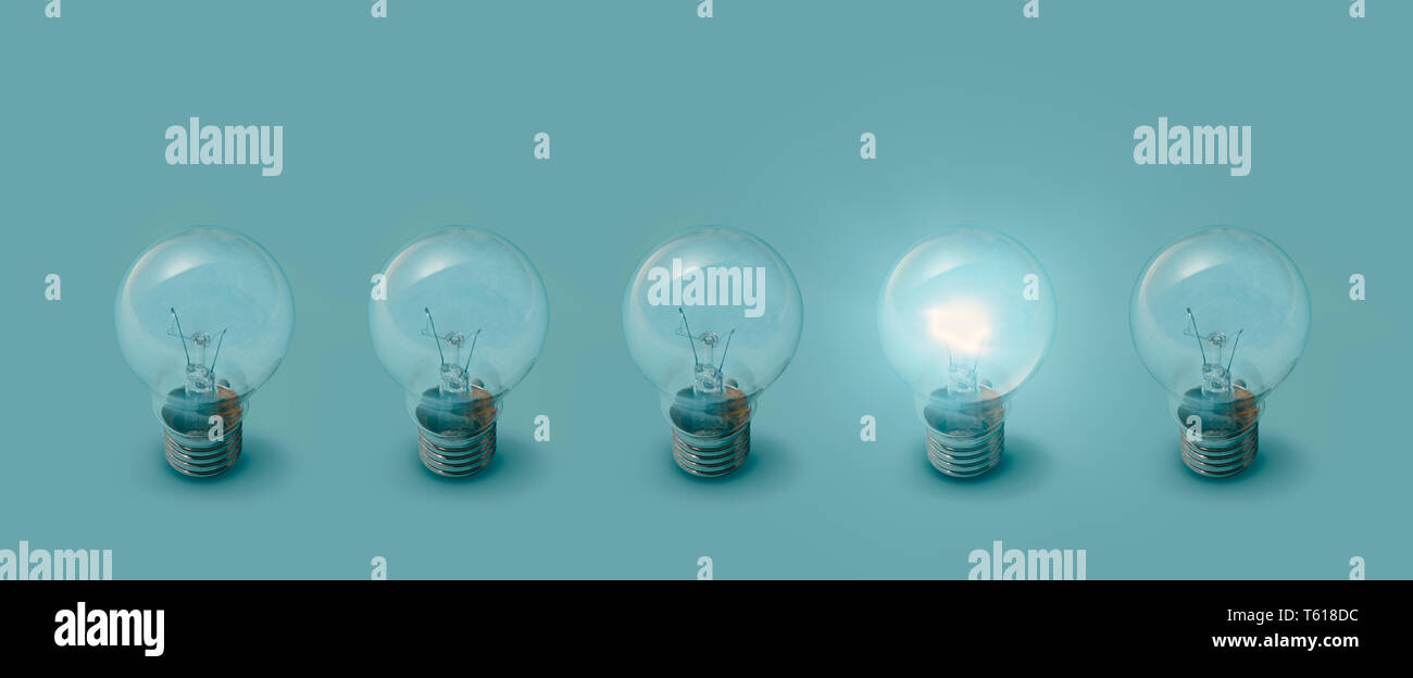 One lit bulb next to unlit bulbs: creativity, ideas and inspiration concept Stock Photo