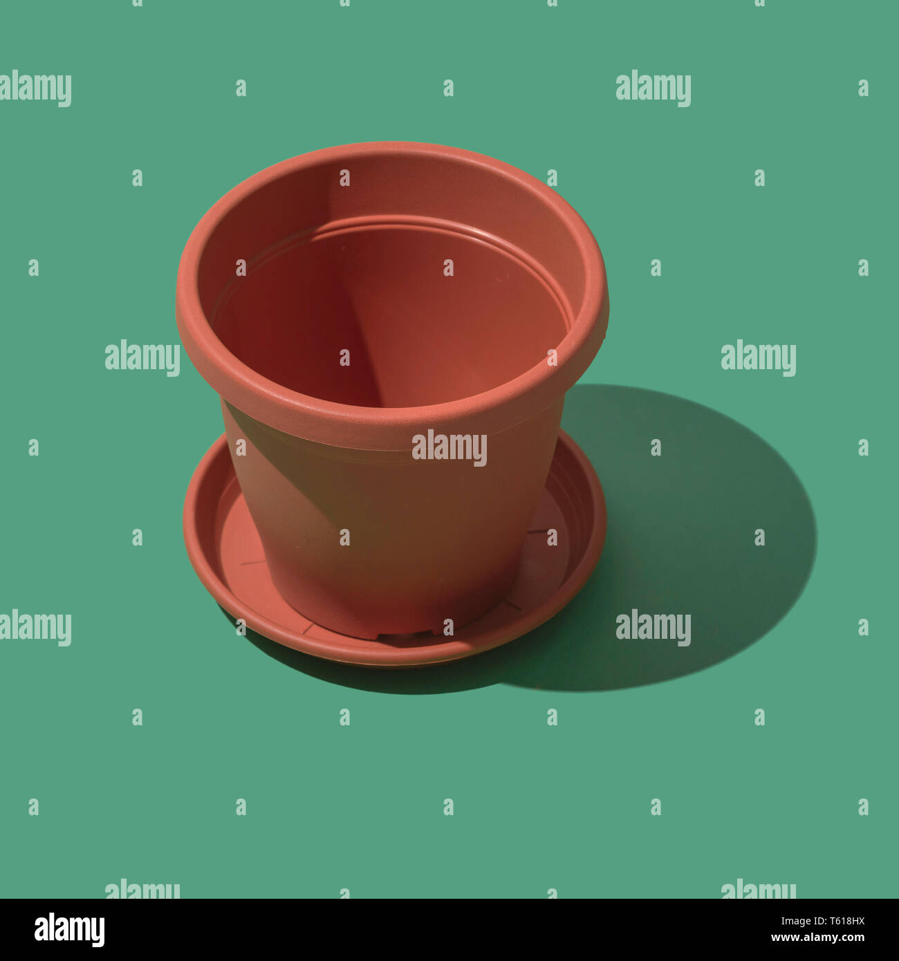 Plastic empty flower pot on green background, gardening and hobby concept Stock Photo