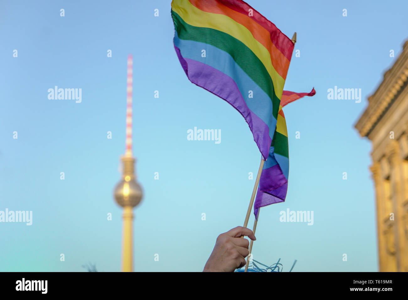 LOW ANGLE VIEW OF HAND HOLDING RAINBOW FLAG DURING CSD-PARADE IN BERLIN Stock Photo
