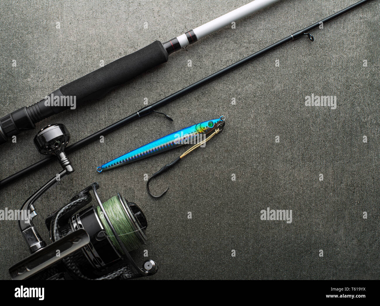 Fishing gear with rod and reel with line ready for jigging on gray
