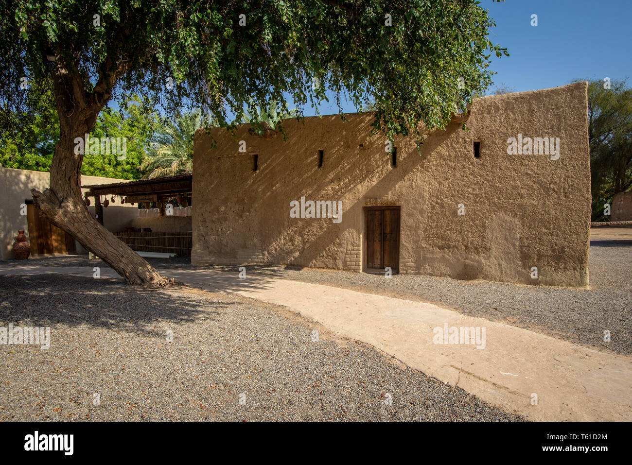 Traditional renovated Arabian building with a natural coulor small wood door and 4 small windows, Al Ain, UAE Stock Photo