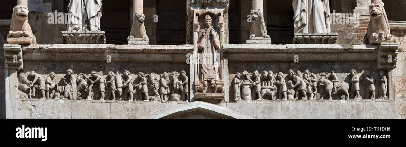 Cremona, il Duomo, facciata, Loggia sopra il protiro del Portale Maggiore: Madonna con Bambino tra i santi Omobono e Imerio Vescovo; fregio marmoreo d Stock Photo