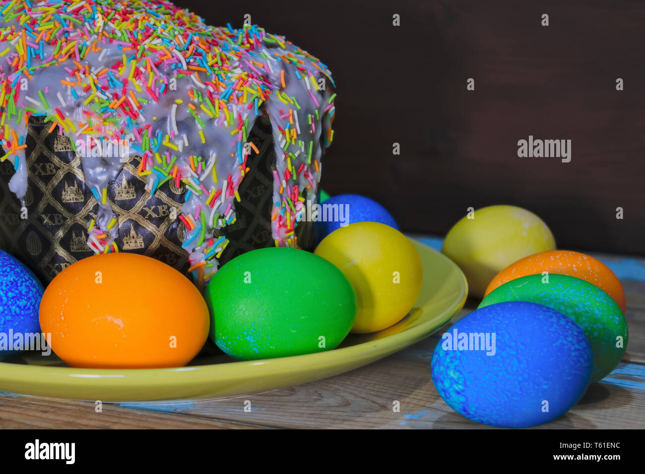 Beautiful Easter composition with Easter cake and painted eggs on wooden table. Copy space. Stock Photo