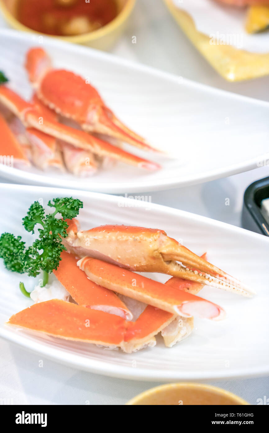close up Japanese claw and leg steamed crab on white dish, decorate with vegetable beside. Stock Photo