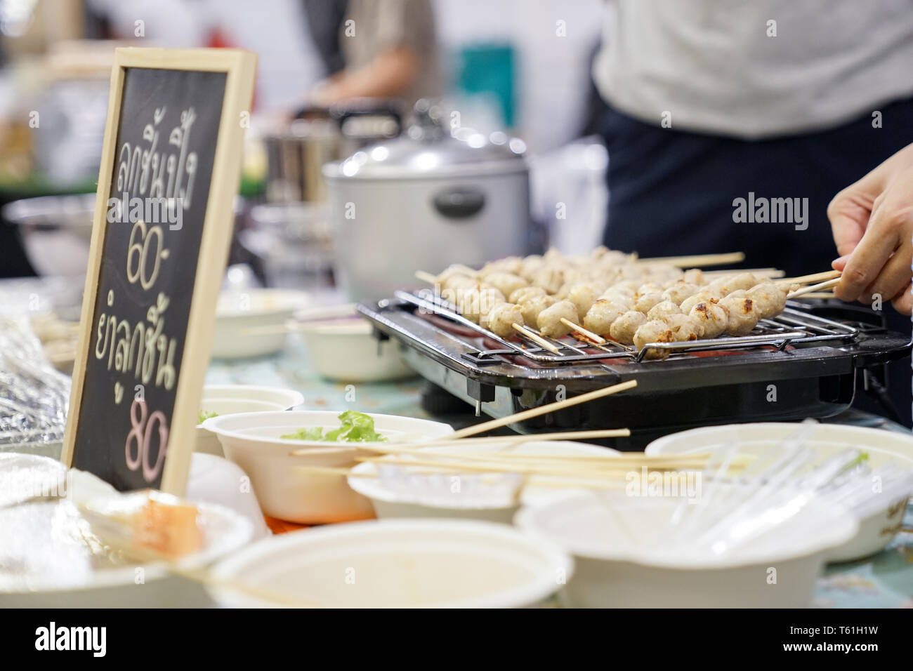grilled meat ball on the elctric grilling. The meaning in Thai letter