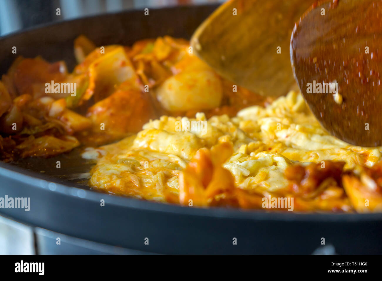 Tokboki (Korean tranditional food hot and spicy rice cake), combination and apply puff with cheese and vegetable on the black table Stock Photo