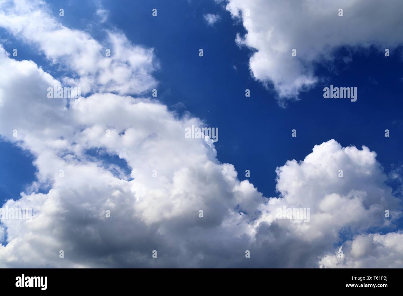 Beautiful fluffy white clouds covered in sunlight on a deep blue sky ...