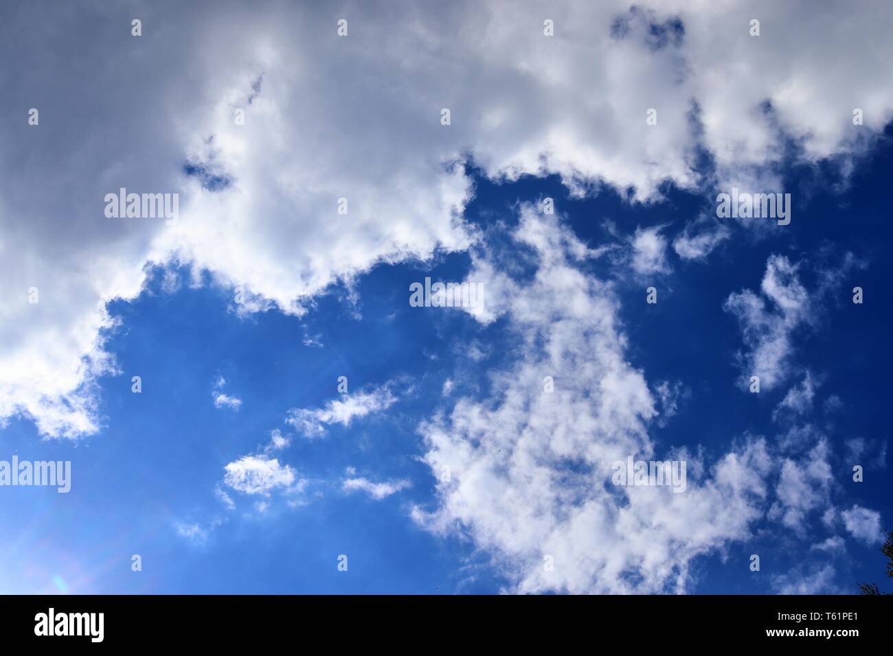 Beautiful fluffy white clouds covered in sunlight on a deep blue sky ...