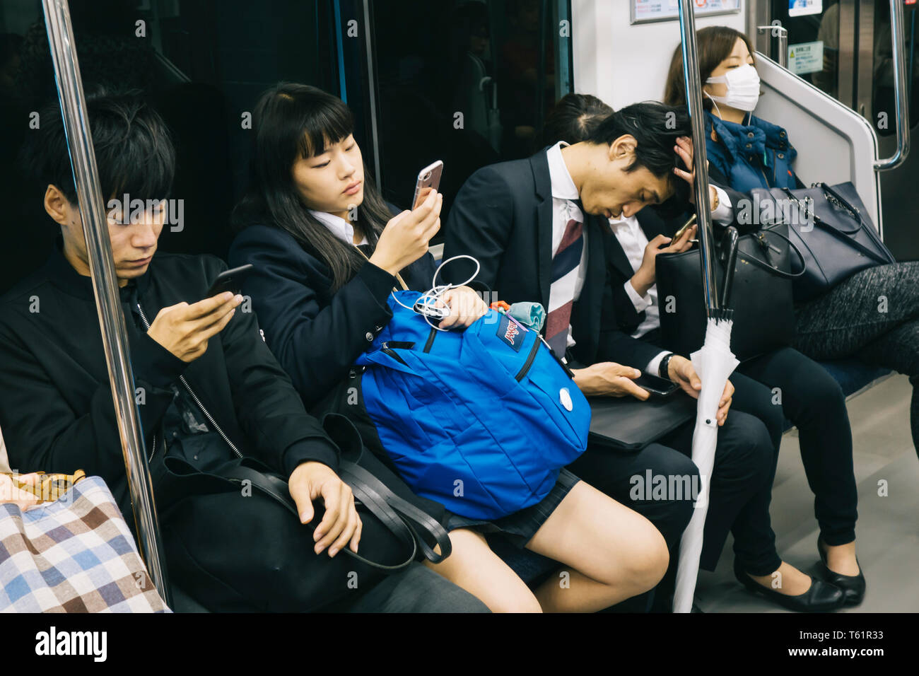 Japanese people sleeping and looking the mobile phone in the Tokyo subway wagon Stock Photo