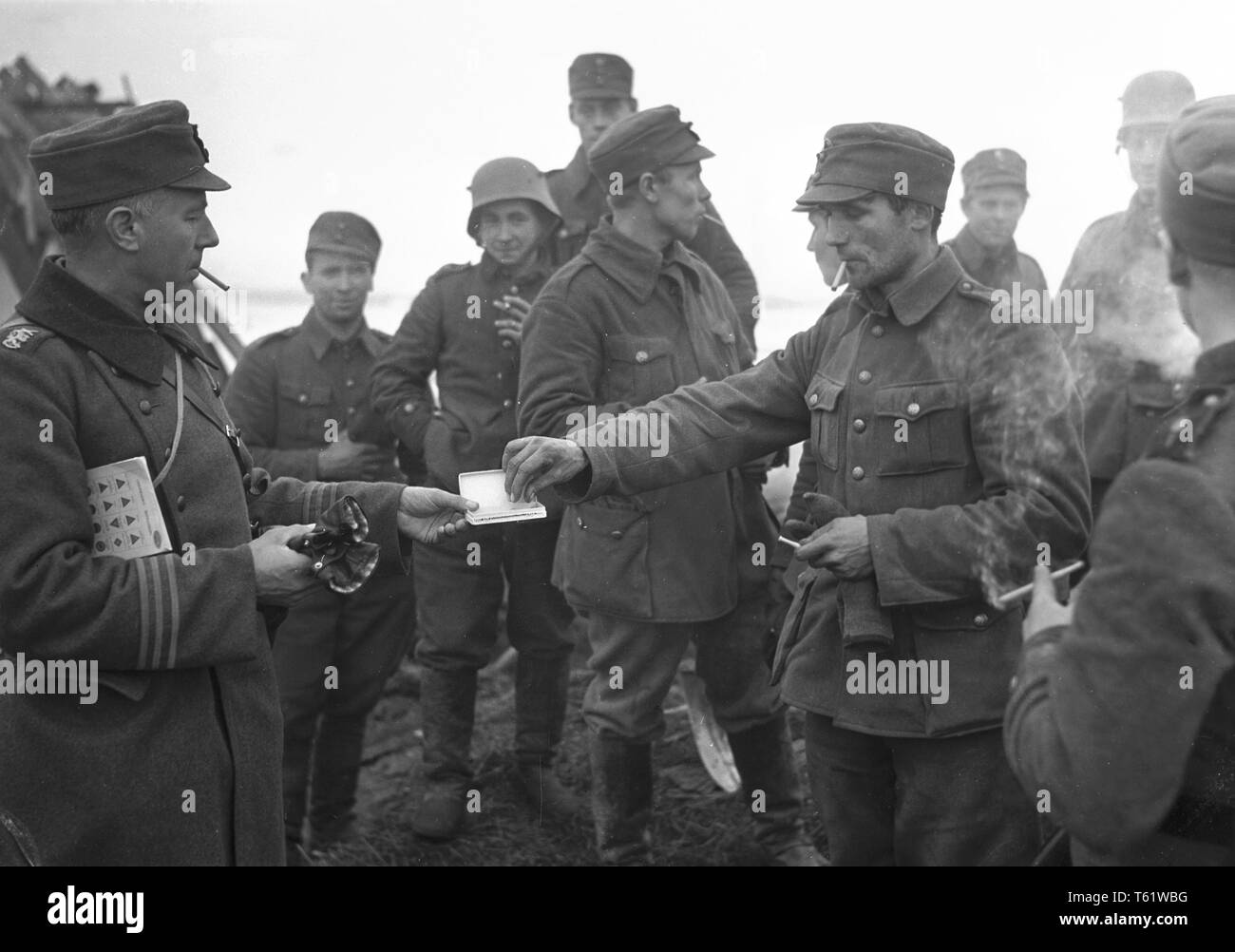 The Winter War. A military conflict between the Soviet union and Finland. It began with a Soviet invasion on november 1939 when Soviet infantery crossed the border on the Karelian Isthmus.  A finnish officer offers cigarettes to finnish soldiers close to the Mannerheim Line on the Karelia. January 1940. Photo Kristoffersson ref 95-19 Stock Photo