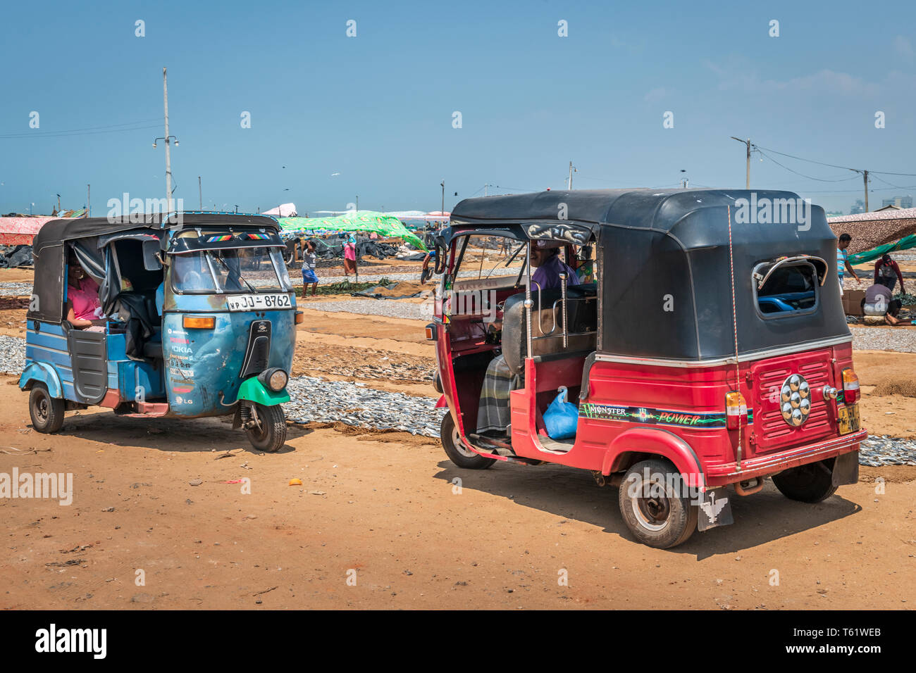 Two Tuk Tuk's, motorised rickshaw's, wait for customers at the famous Negombo Fish Market in Sri Lanka. Stock Photo