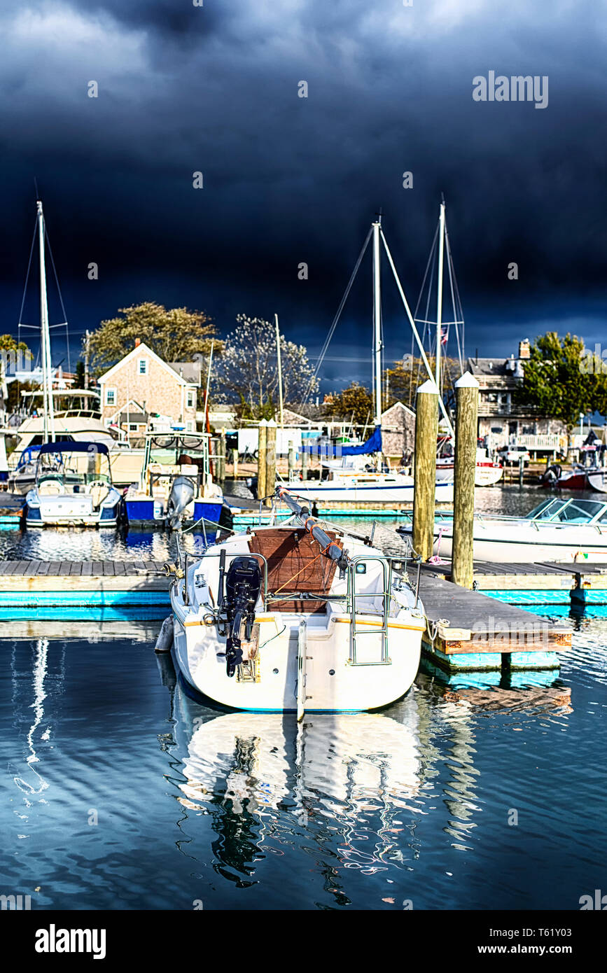 A variety of different boats docked in the inner harbor on Lewis Bay in Hyannis Massachusetts against a stormy sky in new england. Stock Photo