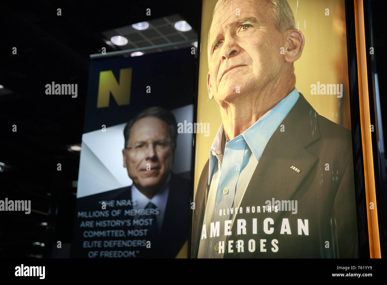 Indianapolis, Indiana, UK. 27th Apr, 2019. Photos of NRA Chief Executive and Executive Vice President Wayne LaPierre (L) and former president of the NRA Oliver North (R) are on display during the third day of the National Rifle Association convention being held nearby. Credit: Jeremy Hogan/SOPA Images/ZUMA Wire/Alamy Live News Stock Photo