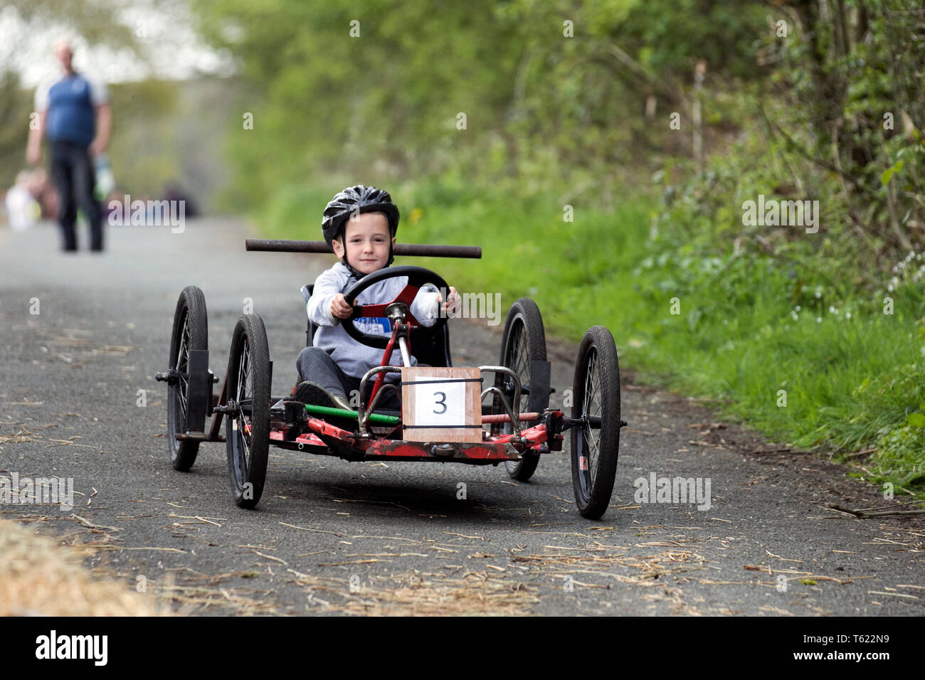 Soapbox derby in Wray, Lancashire, UK. 28th April, 2019. Wacky Wrayces; Robert Woodhouse, 10 years old at the Scarecrow Festival competing in the junior soap box derby races. The 2019 theme, chosen by the local school, is to highlight the themes of “Evolution: Extinct, Endangered, Existing” This fun festive community event the annual Wray Scarecrow Festival in Lancashire is now in its 26th year and draws thousands of visitors to the rural village for the April celebration. Credit: MediaWorldImages/AlamyLiveNews. Stock Photo
