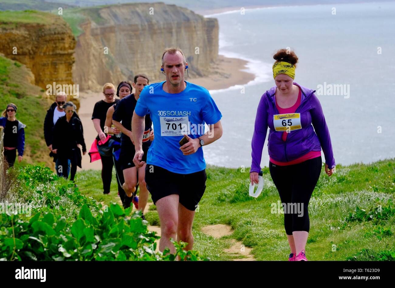 West Bay, Dorset, UK. 28 April 2019. As Storm Hannah subsides runners face the challanging hills of Dorsets Jurassic Coastline as they take part in the  annual Jurrasic  Trail race Credit: Tom Corban/Alamy Live News Stock Photo