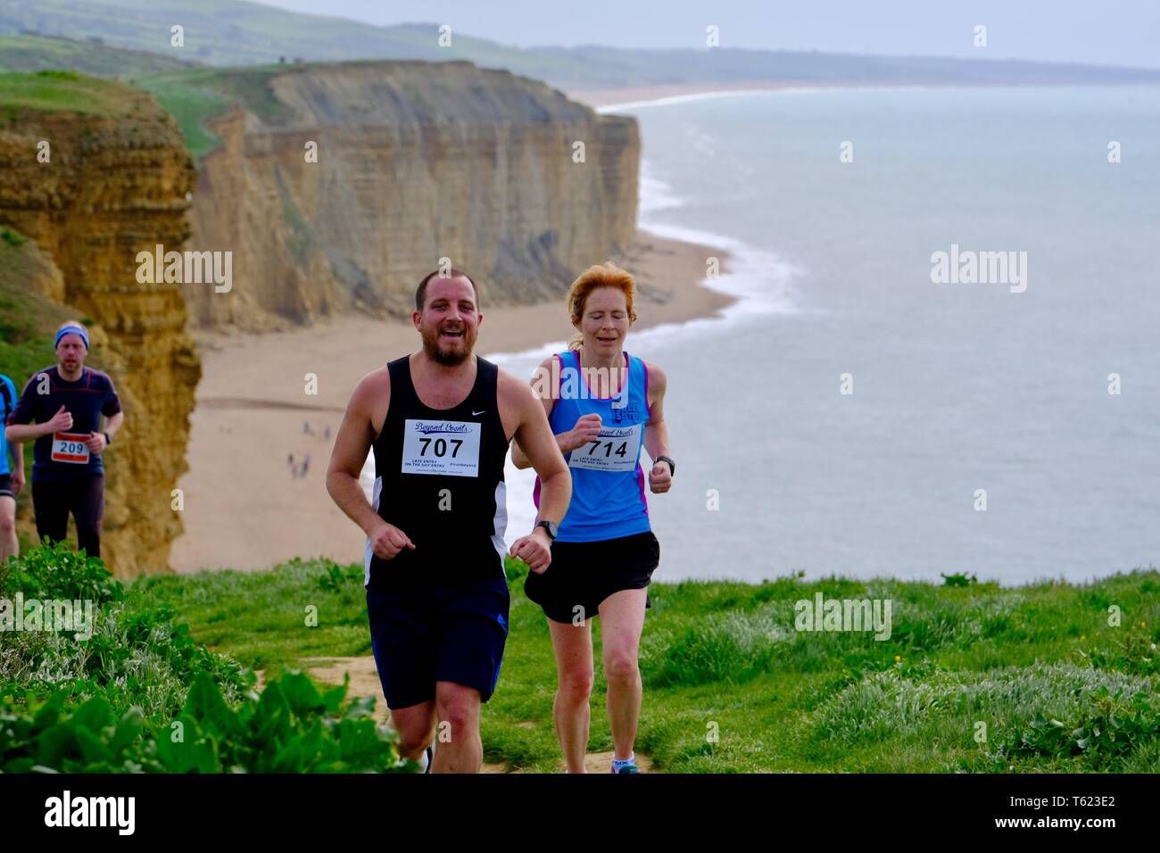 West Bay, Dorset, UK. 28 April 2019. As Storm Hannah subsides runners face the challanging hills of Dorsets Jurassic Coastline as they take part in the  annual Jurrasic  Trail race Credit: Tom Corban/Alamy Live News Stock Photo