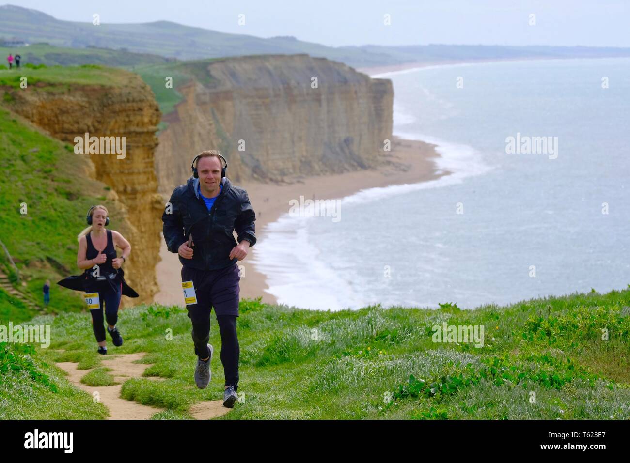 West Bay, Dorset, UK. 28 April 2019. As Storm Hannah subsides runners face the challanging hills of Dorsets Jurassic Coastline as they take part in the  annual Jurrasic  Trail race Credit: Tom Corban/Alamy Live News Stock Photo