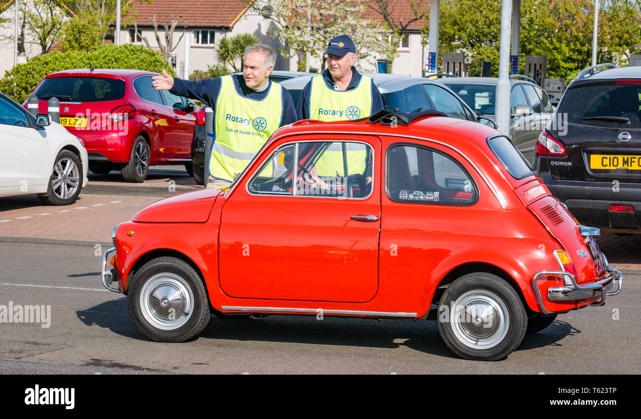 East Lothian, UK. 28 April 2019. Classic Car Tour: North Berwick Rotary Club holds its 3rd rally with 65 classic cars entered. The car rally route is from East Lothian and back through the Scottish Borders, raising money for local charities. The cars gather in North Berwick before setting off. A vintage orange 1972 Fiat 500cc Stock Photo