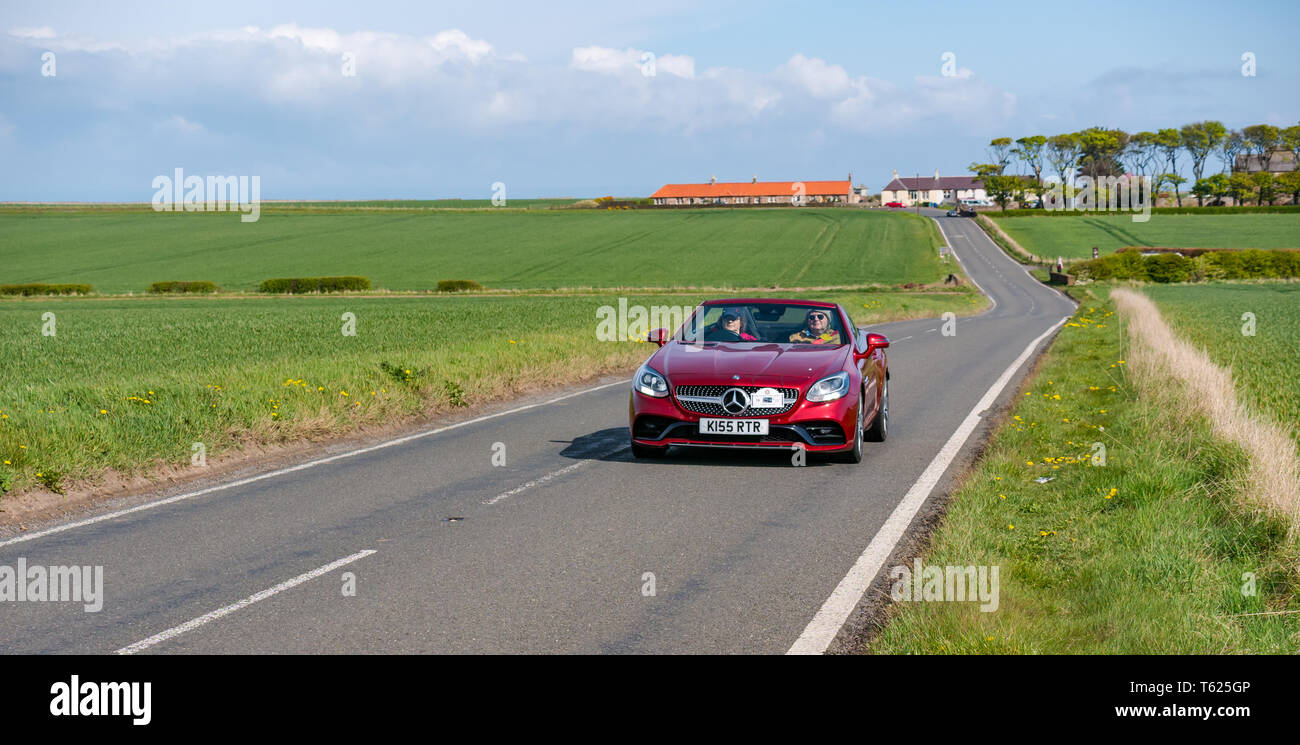 East Lothian, UK. 28 April 2019. Classic Car Tour: North Berwick Rotary Club holds its 3rd rally with 65 classic cars entered. The car rally route is from East Lothian and back through the Scottish Borders, raising money for local charities. A 2016 Mercedes Benz convertible sports car driving on a country road Stock Photo