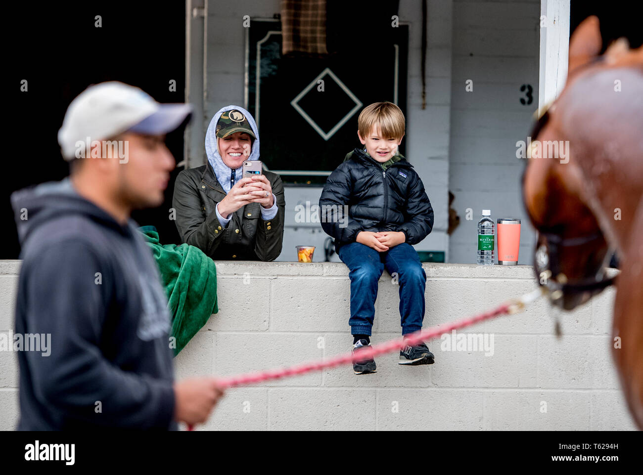 Louisville, Kentucky, USA. 28th Apr, 2019. LOUISVILLE, KENTUCKY - APRIL 28: Tripp McFadden, 4, and his mother Lisa watch as Country House, trained by William Mott, gets a bath after exercising in preparation for the Kentucky Derby at Churchill Downs in Louisville, Kentucky on April 28, 2019. The McFaddens, from Lexington, KY are part owners of the Derby prospect. Scott Serio/Eclipse Sportswire/CSM/Alamy Live News Stock Photo