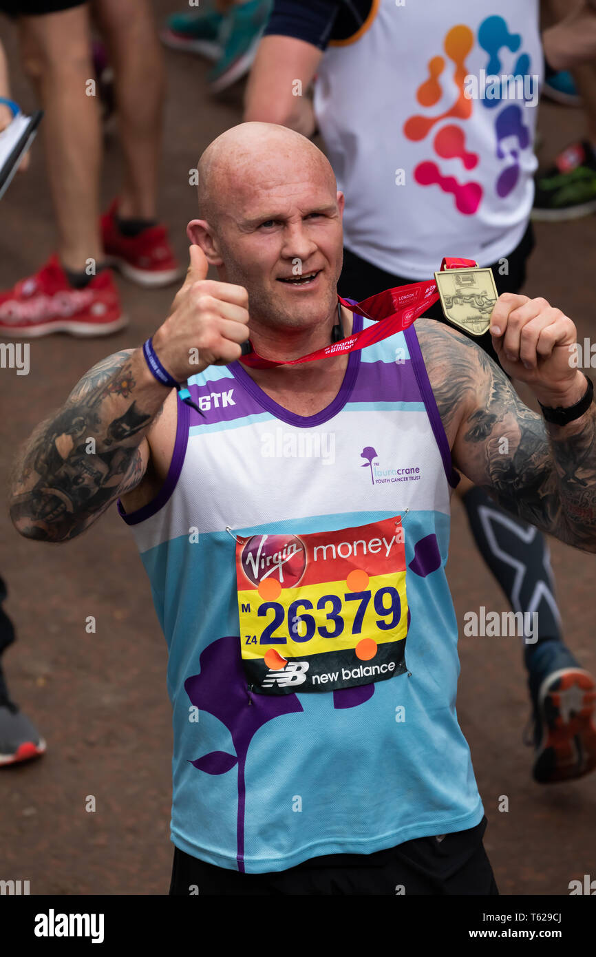 London, UK. 28th April 2019. Keith Senior, English former rugby player with his medal after completing The 39th London Marathon. Credit: Keith Larby/Alamy Live News Stock Photo
