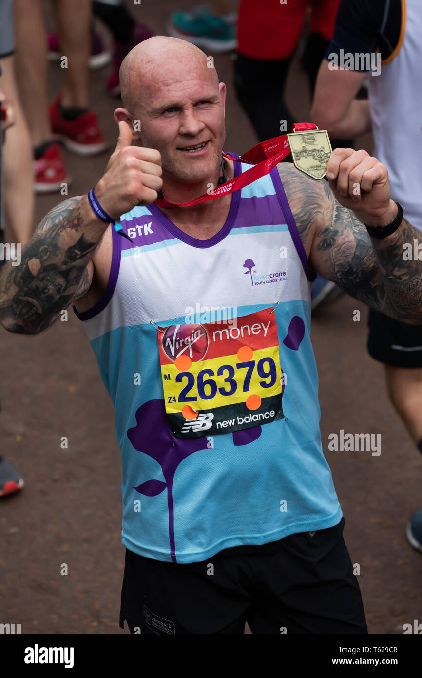 London, UK. 28th April 2019. Keith Senior, English former rugby player with his medal after completing The 39th London Marathon. Credit: Keith Larby/Alamy Live News Stock Photo