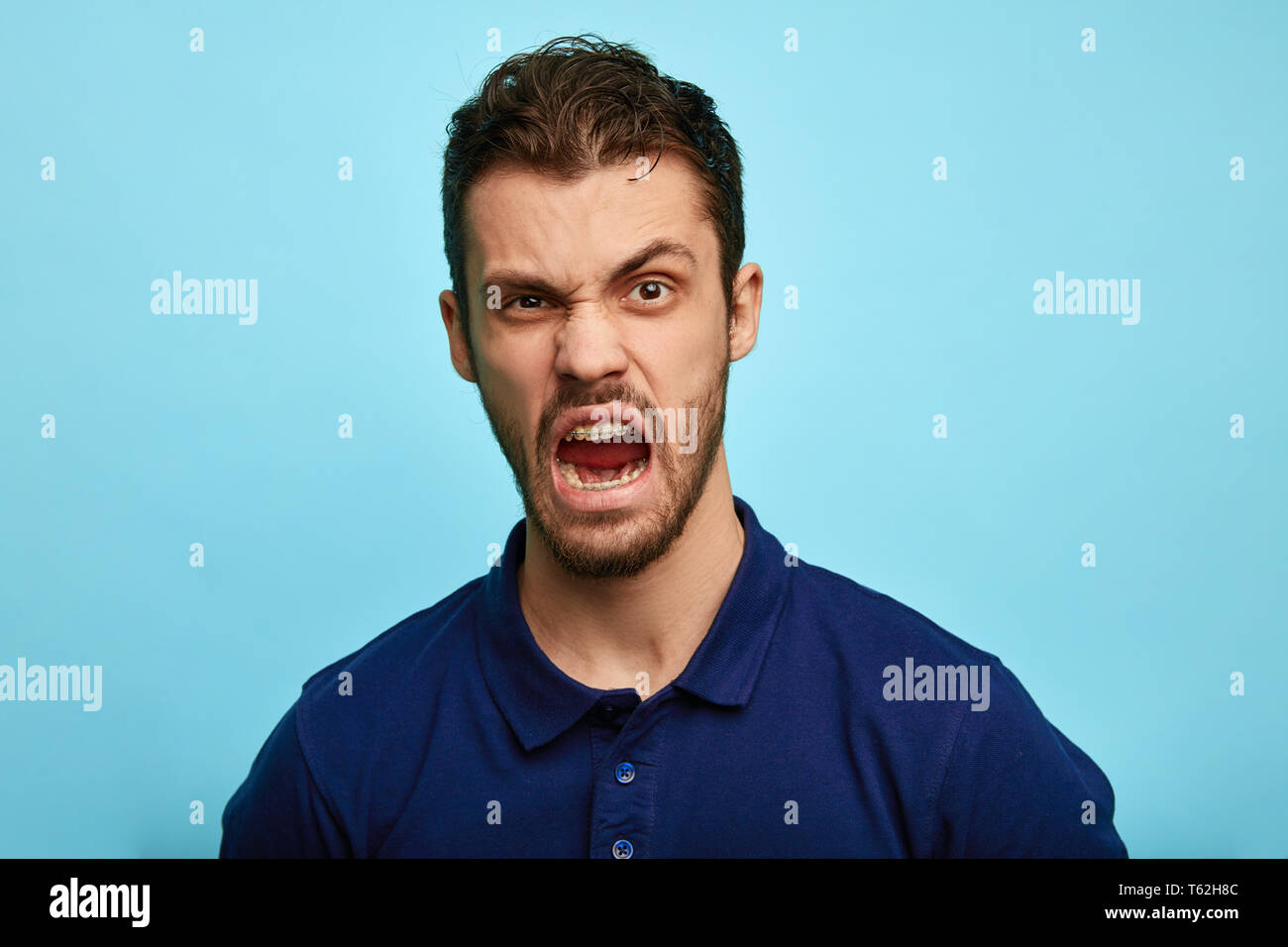 frustrated, enraged man with grumpy grimace on his face, scolding somebody, expresses negative emotion, irritation concept. Stock Photo