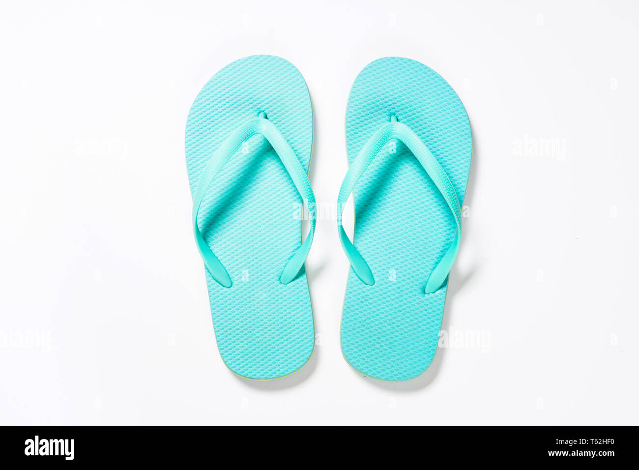 Blue flip flops on white background Stock Photo - Alamy