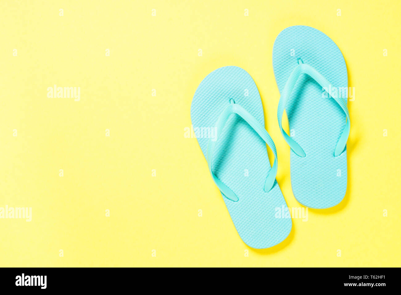Blue flip flops on yellow background Stock Photo - Alamy