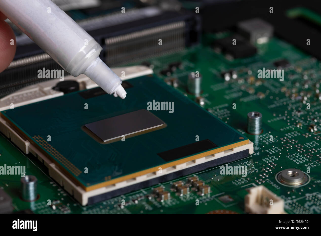 A tube of thermal grease over the processor chip. Computer assembly ...