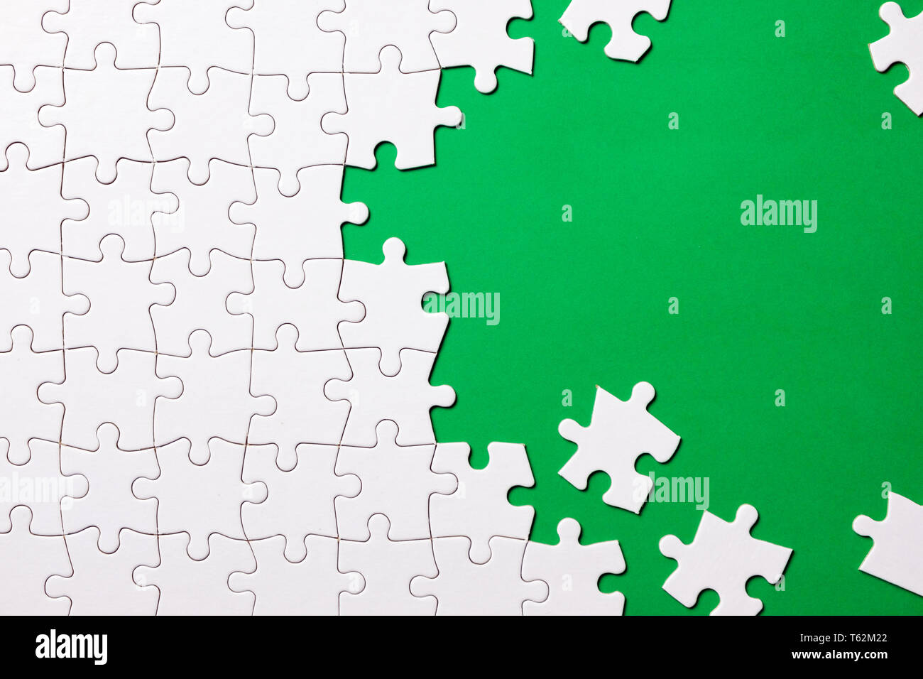 White jigsaw puzzle on green background Stock Photo